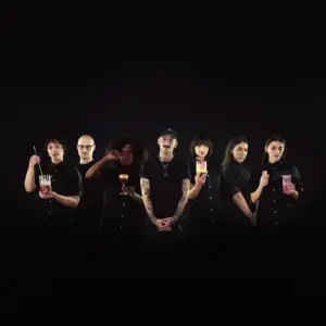 Composed potograpyh of seven people dressed in black in front of black background.